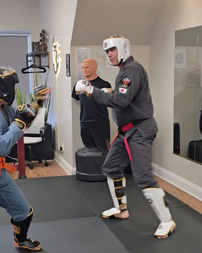 Renshi JP Perron training in protective headgear and shin guards at the Vanguard dojo