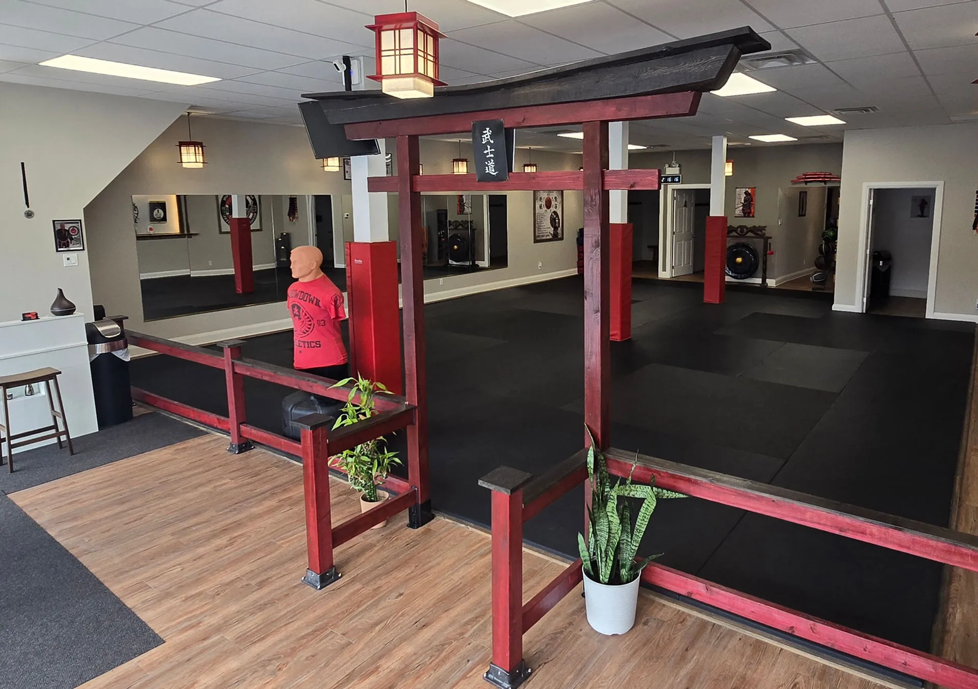 Vanguard dojo interior with black training mats, red torii entry, and a standing training dummy