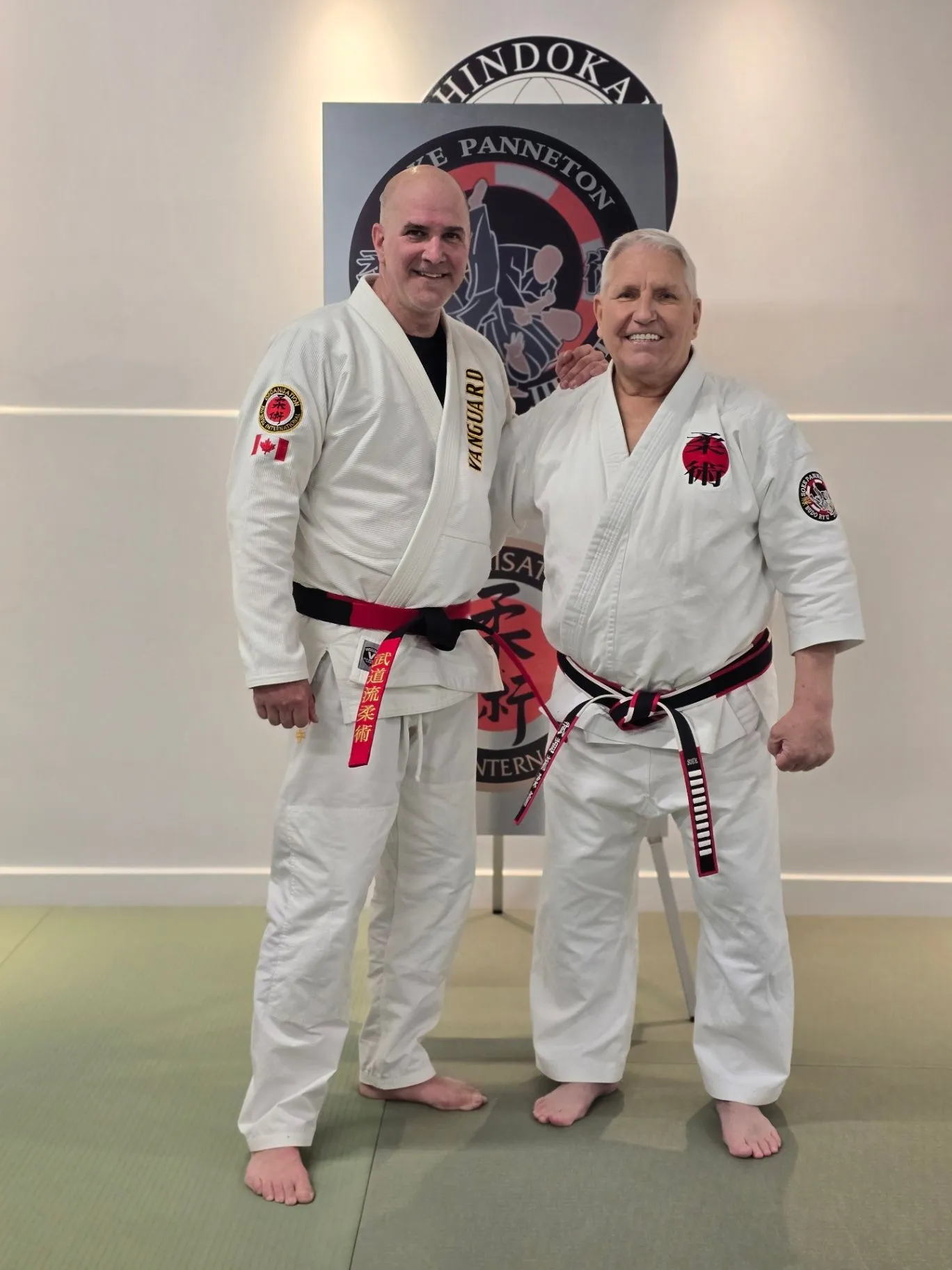 Renshi JP Perron standing beside Sōke Robert Panneton in white Vanguard gis